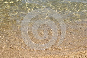 Sand beach, coastline and crystalline clear water in sea.