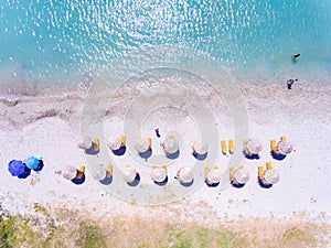 Sand beach in Greece aerial view with umbrellas and sunbeds