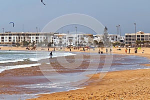 Sand beach with the resting people on the Atlantic coast. Essaouira, Morocco