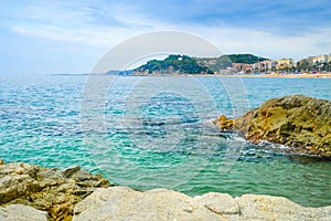 Sand beach with rocks in cloudy weather in Lloret de Mar, Costa Brava Spain. Concept of rest