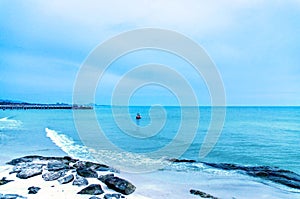 The sand beach and sea with fishing boat that parked on the beachfront with rock and reef in morning with sunrise