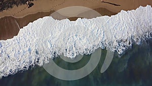 Sand beach. Stock. Top view of a beautiful sandy beach with the blue waves rolling into the shore. Sea background