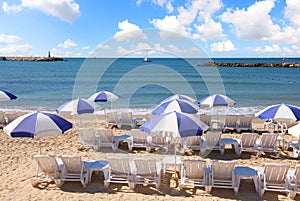 Sand beach with sun umbrellas and lounges