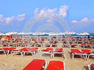 Sand beach with sun umbrellas and lounges