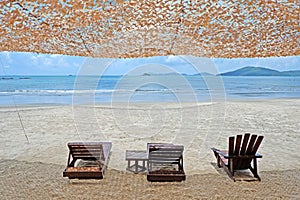 Sand beach, suntain wooden chair, water wave, blue sky and white cloud in summer