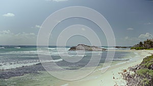 Sand beach and turquoise carribean sea on blue sky background.