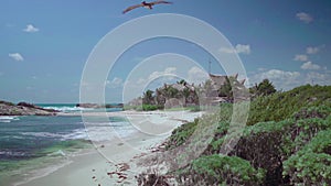 Sand beach and turquoise carribean sea on blue sky background.