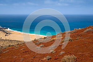 Sand beach under a red volcano