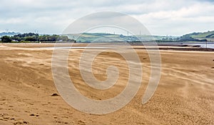 Sand blowing across the beach at the village of Llansteffan, Wales