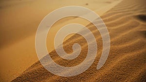 Sand blowing over sand dunes in wind, Sahara desert, Morocco