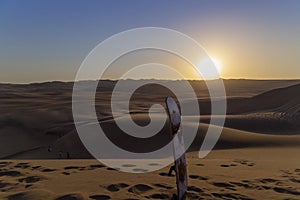 Sand boarding ,Dune Buggy parked in the desert during sunset at Huacachina Oasis in Ica, Peru