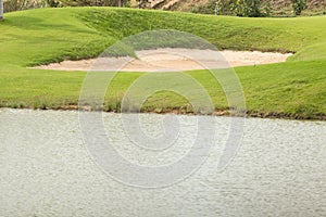 Sand bunker and lake in golf course