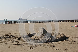 Sand castle with cargo ship in the background