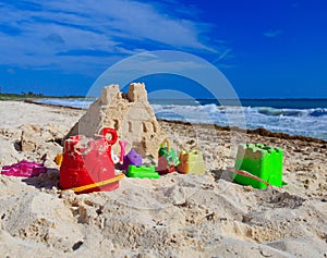 Sand castle with kids toys built on the beach