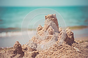 Sand castle standing on the beach. Travel vacations concept.