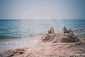 Sand castle standing on the beach. Travel vacations concept.