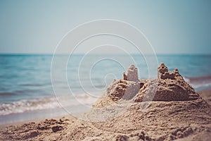 Sand castle standing on the beach. Travel vacations concept.