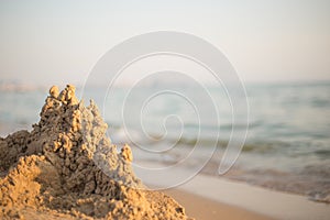 Sand castle standing on the beach. Travel vacations concept.