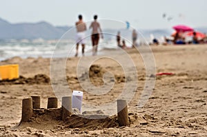 Sand castle and tourists on Spanish beach