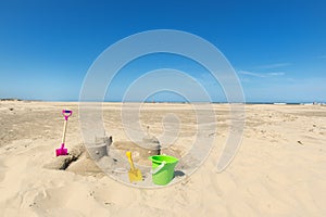 Sand castle with toys at the beach photo