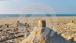 Sand castles on the beach with the ocean in the background, summer holiday background video