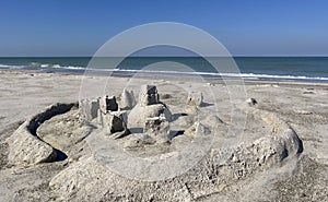 Sand castles on beach with ocean and blue sky in background