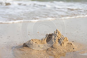 Sand castles destroyed by sea water But the remains of the ruined soil Summer concept Unsustainable and uncertain photo