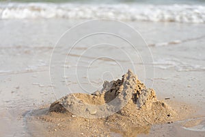 Sand castles destroyed by sea water But the remains of the ruined soil Summer concept Unsustainable and uncertain photo