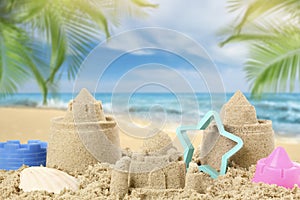 Sand castles with toys on beach. Outdoor play