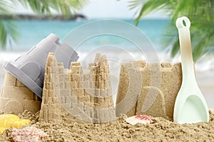 Sand castles with toys on ocean beach, closeup