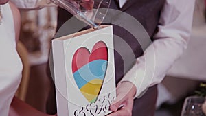 Sand ceremony at the wedding. Groom closes the tube of glass vessel filled with sand of different colors at the wedding