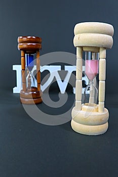 Sand Clock representing woman in front of man photo