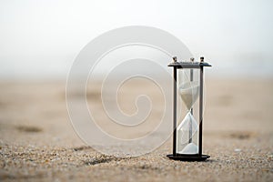 Sand clock on the beach, business time management concept