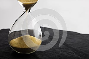 Sand clock , Hourglass as time passing on black slate background , Life time concept