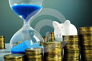 Sand clock, piggy bank and money. Bank deposit and savings