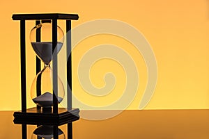 Sand clock on yellow background
