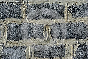 The sand-colored plaster between gray bricks