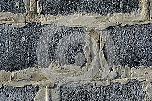 The sand-colored plaster between gray bricks
