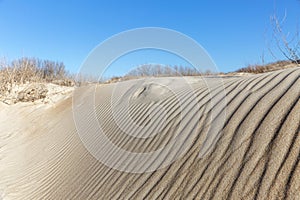 Sand dune against the blue sky. Beautiful coastal landscape