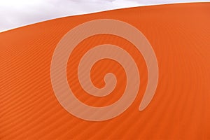 Sand dune, detail of blown orange sand, structure and patterns of the dune, Africa