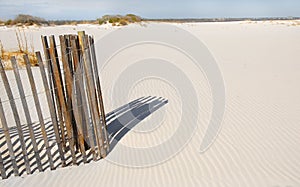 Sand dune fence by rippled sand