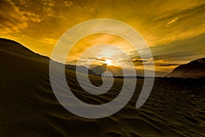 Sand dunes against the background of distant colorful mountain r