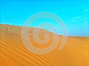 Sand dunes and blue sky in desert of Algeria