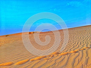 Sand dunes and blue sky in desert of Algeria