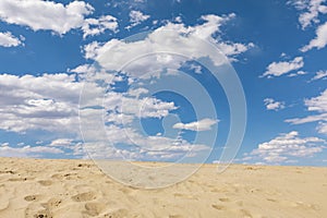 Sand dunes and blue sky with white clouds