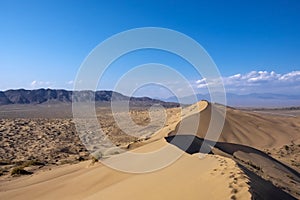 Sand dunes with clouds backgorund. Natural landscape. Altyn-Emel singing dunes or barkhan. Altyn-emel national park in Kazakhstan.