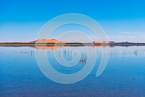 A sand dunes of Erg Chebbi and reflection on a lake. Landscape shot taken near town Merzouga, Sahara Desert, Morocco