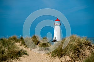 The sand dunes, and the grade II listed building Point of Ayr Lighthouse at Talacre beach in Wales on a sunny summer day photo