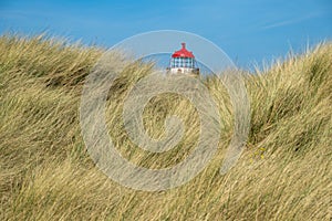 The sand dunes, and the grade II listed building Point of Ayr Lighthouse at Talacre beach in Wales on a sunny summer day photo