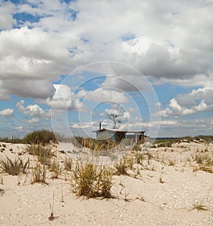 Sand dunes and a house in the foreground